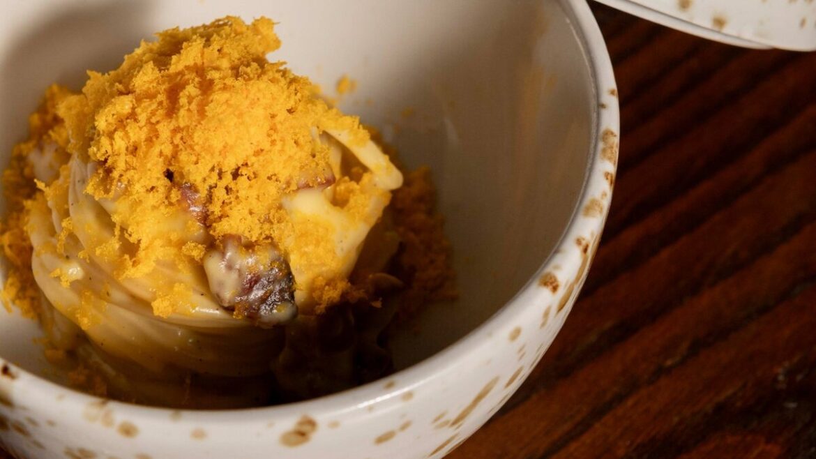 La Carbonara dell'Insolita Trattoria Firenze: crema pasticciera e tuorlo grattato come bottarga, servita in una ciotola maculata con coperchio