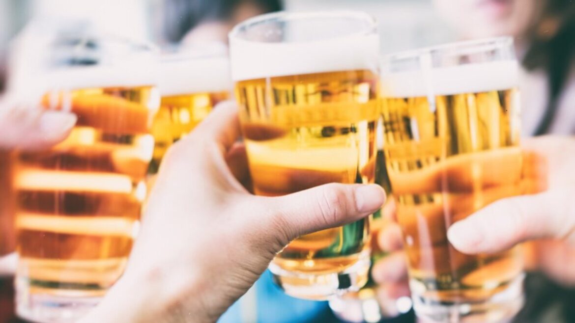 Brindisi con bicchieri di birra chiara tra amici, simbolo del tempo di qualità secondo la ricerca Ichnusa