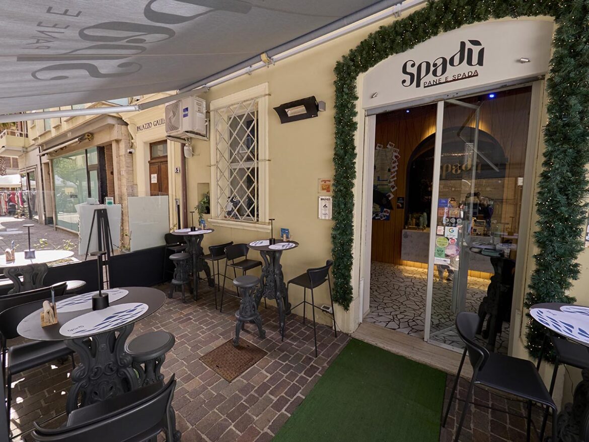 Esterno del bistrot contemporaneo Spadù – Pane e Spada a San Benedetto del Tronto, con i tavoli all'aperto e l'ingresso decorato