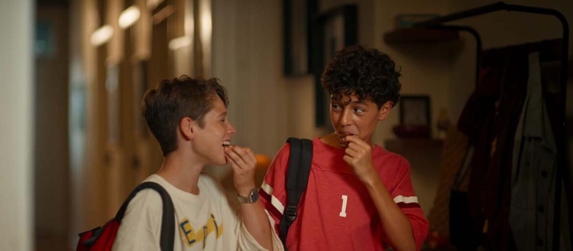 Due ragazzi sorridono e condividono una merenda con il nuovo biscotto Ringo feat Gocciole.