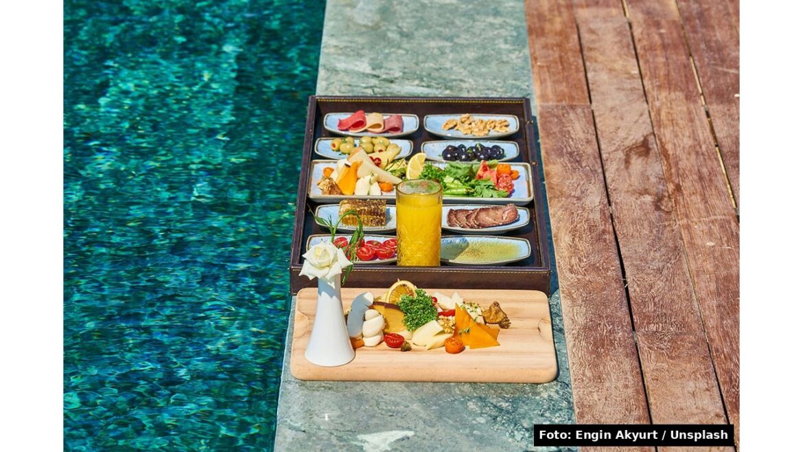 Tagliere di aperitivo con formaggi, salumi e frutta a bordo piscina