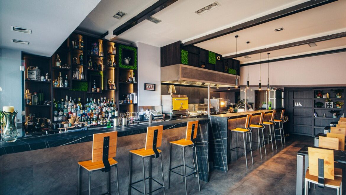 Bancone del cocktail bar SURF a Imperia con bottiglie e postazione cucina a vista